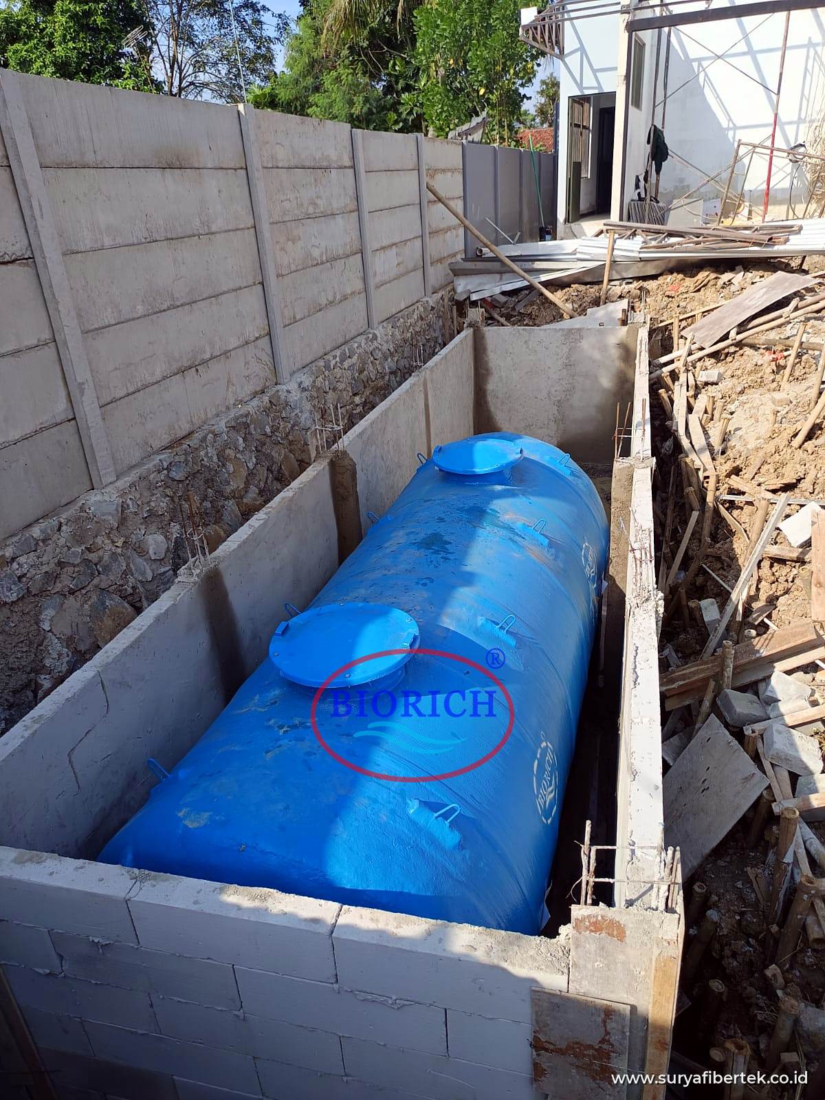 Tangki IPAL BIORICH ditempatkan di bak beton sebelum ditimbun, dengan tutup manhole di bagian atas